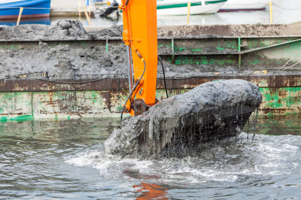 istock Excavator shovel digging in sand from water 1195381847