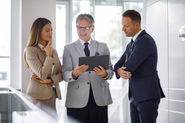 istock Group of mixed aged business people collaborating over digital tablet 1195383924