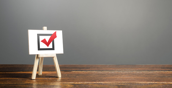 Easel with red voting tick. Checkbox. Democratic elections, referendum. Right to choose, change of power. Checklist verification, self-discipline. Necessary quality criteria, skills, approval symbol