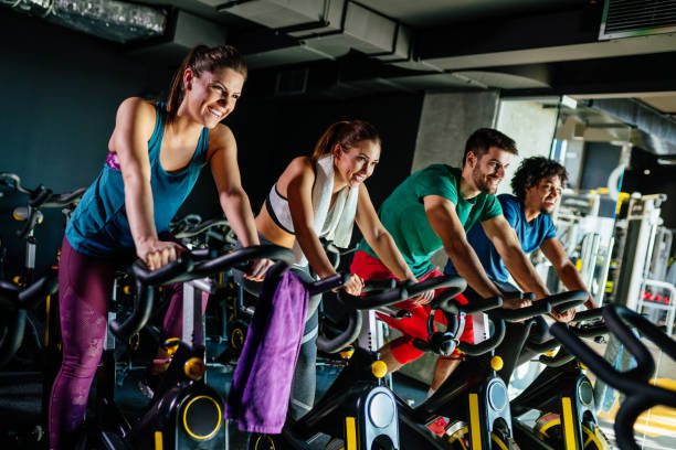 istock Group of young people exercising on exercise bikes at gym 1195385836