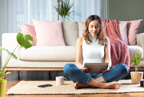 istock Young woman using digital tablet at home 1195388082