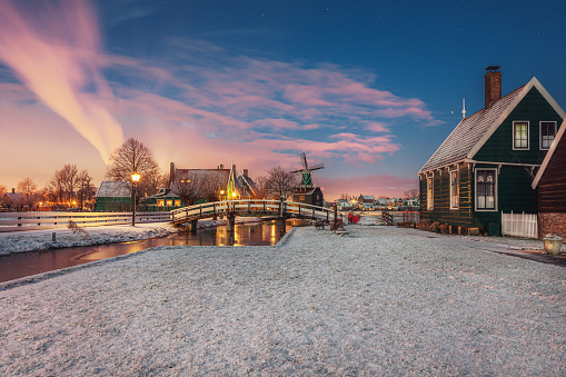 Small mill and typical Zaanse houses on the Zaans Schans in winter located on the river De Zaan in the Netherlands
