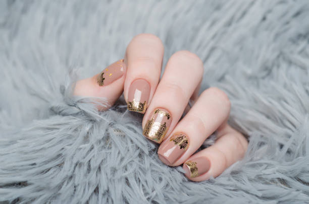istock beige Nude manicure with gold lace pattern on a gray background 1195392557