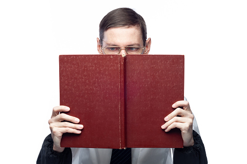 The man's face is covered by a large red notebook, on an isolated background