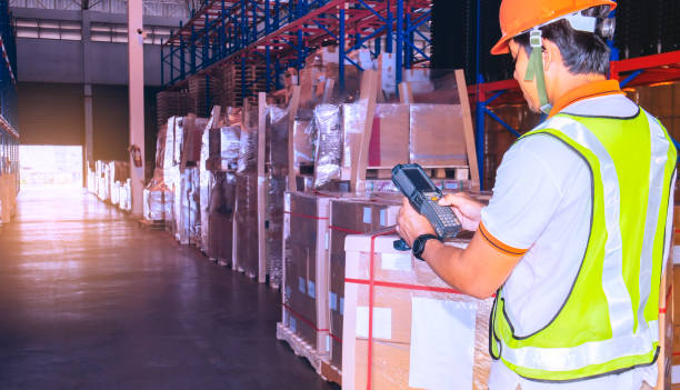 istock Asian worker man hand holding bar code scanner inspecting the products package in storage warehouse 1195392810