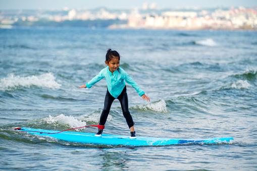 Six year old girl surfing in Okinawa, Japan