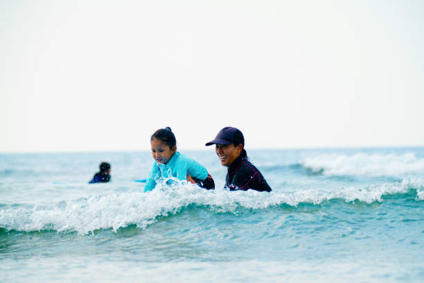 istock Young girl taking a surfing lesson 1195393579