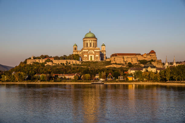 Aerial view of Esztergom Basilica, Hungary’s largest church, situated on Castle Hill above the Danube River. The surrounding hills, fortifications, and town provide a scenic backdrop under the bright summer sky. Esztergom in Hungary - Europe