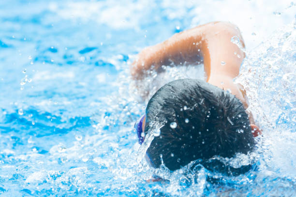 istock ASIAN BOY SPRINTS FREESTYLE SWIMMING 1195401886