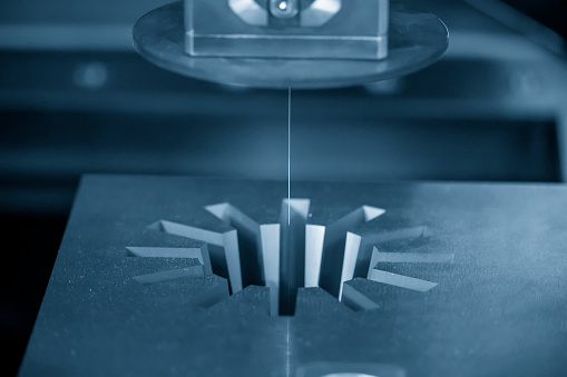 La máquina de edM de alambre corta la forma del engranaje de la plaquita de troquel. photo