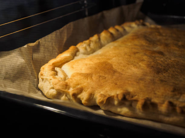 istock Ruddy pie on baking paper in the oven 1195402216