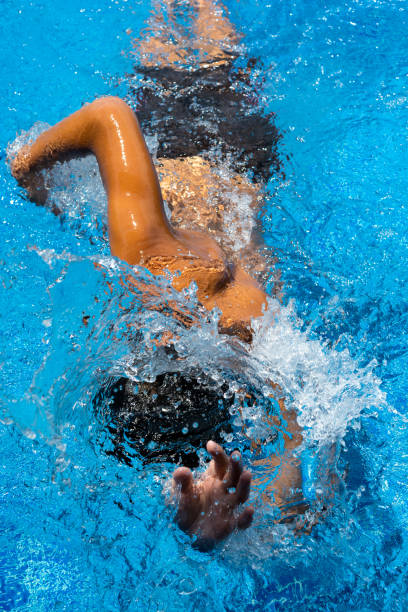 istock ASIAN BOY SPRINTING EXERCISING FREESTYLE SWIMMING IN POOL 1195403372