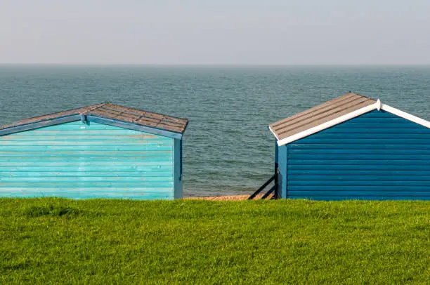 Colourful holiday wooden beach huts facing the calm atlantic ocean.  Whitstable at Kent Great Britain