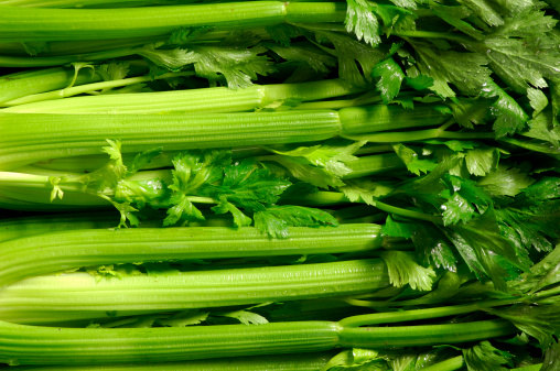 Wooden bowl filled with fresh organic chopped celery