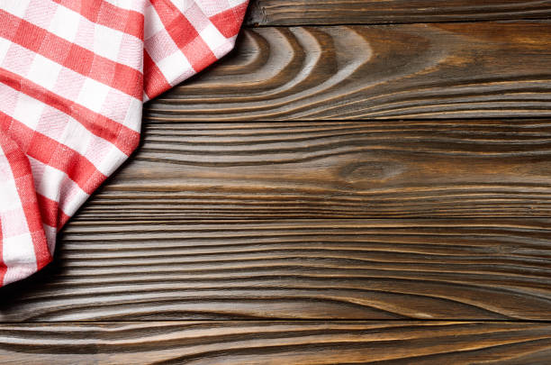 istock Red checkered napkin on brown wooden kitchen table with copy-space. Top view 1195406453