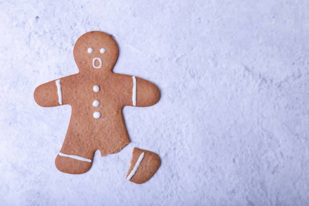 Ginger man with a broken leg (without a leg) and a surprised face. A ginger man with a broken leg (no leg) and a surprised face. Traditional Christmas and Christmas homemade cookies. Selective focus, close-ups. Space for text. gingerbread man stock pictures, royalty-free photos & images