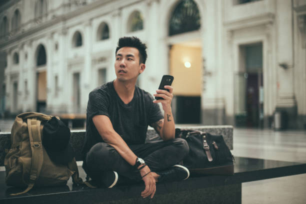 istock Young man is text messaging on a train station 1195411647