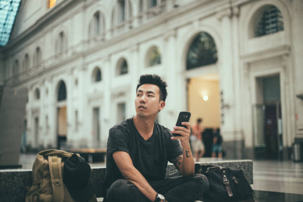 istock Young man is waiting for a train and text messaging 1195412707