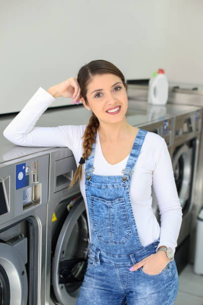 istock Young woman at a laundromat 1195413903