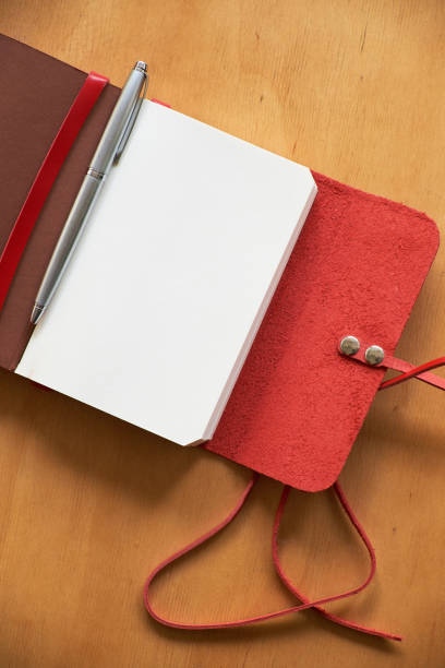 istock An opened notebook for notes lies on a table, near a pen. 1195414157