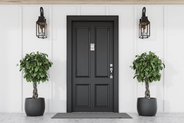 istock Black front door of white house with trees 1195415071