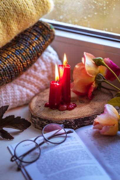 istock Autumn composition on a windowsill reading a book on a rainy evening. 1195418276