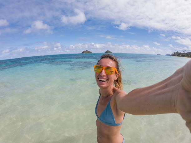 istock Young woman taking selfie on beach 1195419497