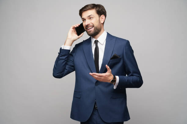 istock businessman talking on the phone isolated over grey background 1195419703
