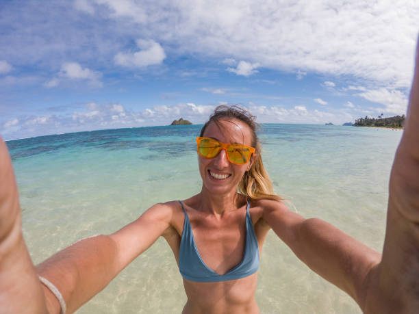 istock Young woman taking selfie on beach 1195419996