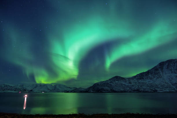 Northern Lights over the Norwegian fjords and mountains A stunning Aurora Borealis display above the snow covered mountains and fjords of Northern Norway. norway aurora borealis aurora polaris fjord stock pictures, royalty-free photos & images