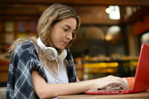 istock Young woman using lap top at cafe 1195422523