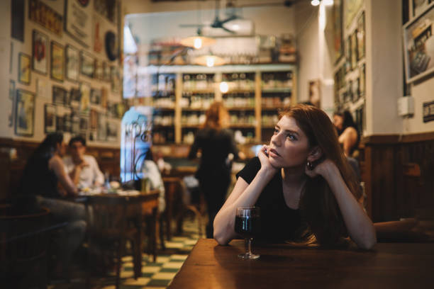 Young woman drinking wine alone in a pub, Buenos Aires, Argentina.
