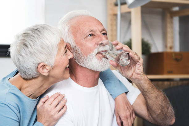 pareja mayor beber agua - adult beverage fotografías e imágenes de stock