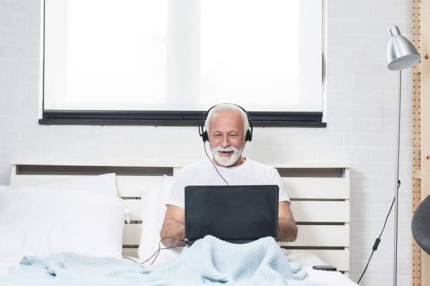 istock Senior man at home connected on laptop computer 1195428373