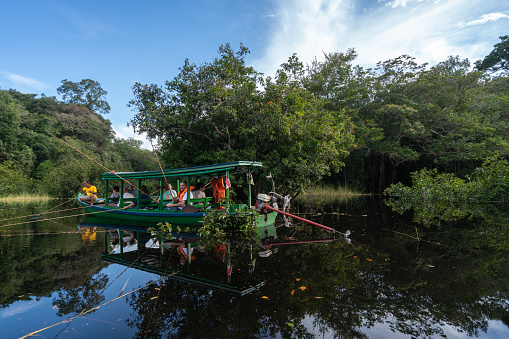 Amazon, Brazil – March 6, 2019: Amazon, Brazil - March 6, 2019: Tourists in a traditional Amazon boat fishing for piranhas.