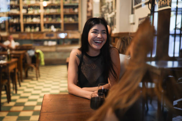 istock Young woman talking with her friend in a pub 1195431108