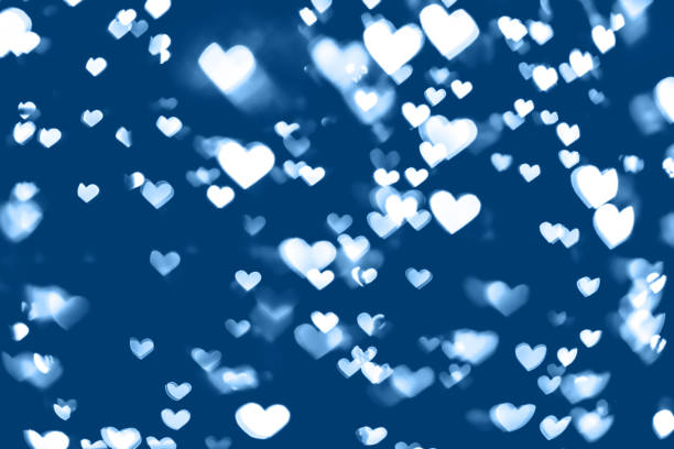 istock blue colored festive background with white heart bokeh 1195432504