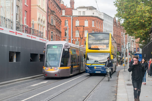 strada di dublino con autobus e tram dei mezzi pubblici a dublino. - republic of ireland dublin ireland bus city foto e immagini stock