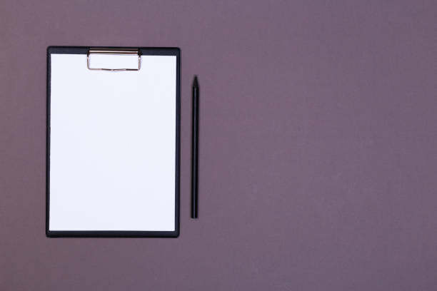 istock Clipboard with white sheet and pen on a colored background. View from above. space for text 1195436593
