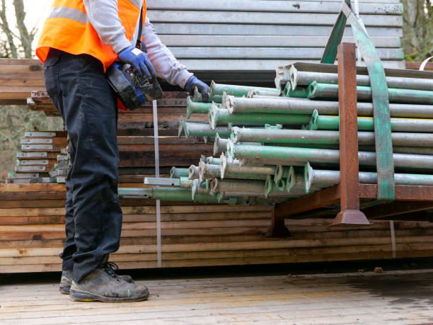 A lorry driver using portable hydraulic controls to move scaffolding