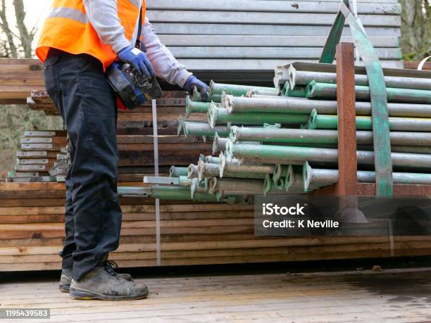 A Lorry Driver Using Portable Hydraulic Controls To Move Scaffolding Stock Photo - Download Image Now