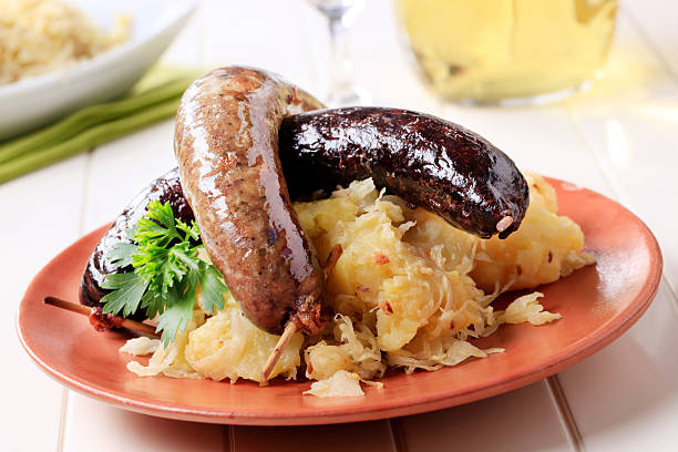 Plate of grilled red sausages served with baked potato and mustard in rectangular plate on the table