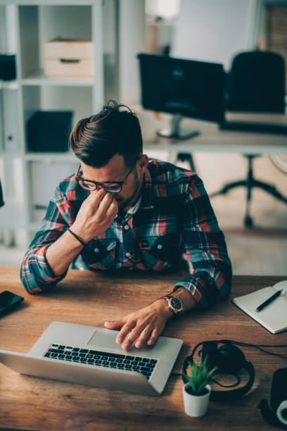 istock Young businessman experiencing stress during a late night at work 1195448612