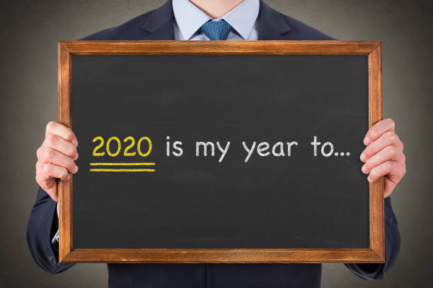 istock Human hand drawing 2020's my year to... on chalkboard background 1195448828