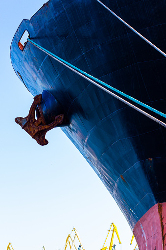 nose of a transport ship with an anchor and mooring ropes