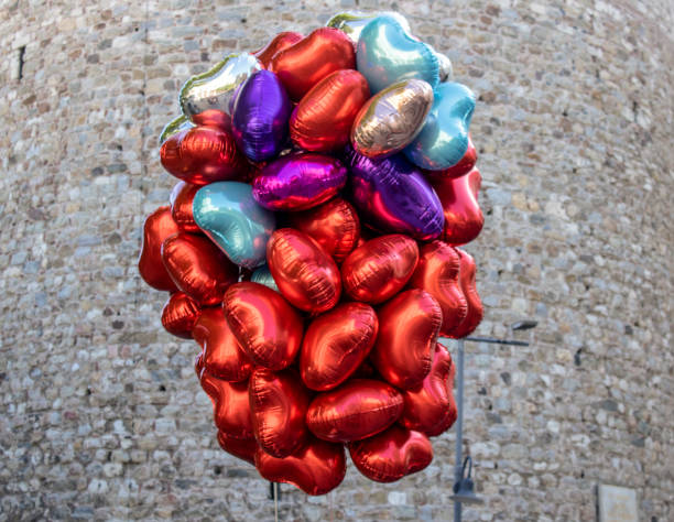 primo-up di un colore diverso e palloncini assortiti del fornitore di palloncini. muro di pietra storico sullo sfondo. - child balloon selling sign foto e immagini stock