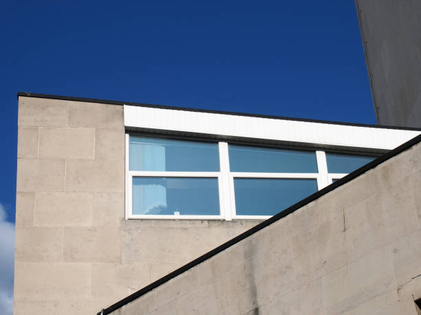 angular close up view of an old 1960s concrete brutalist stye building with blue sky
