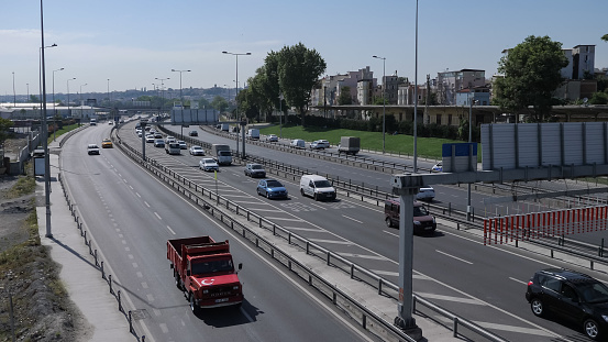 ISTANBUL, TURKEY - JULY 30 2019: Automobiles drive on modern highway running along calm azure sea against clear blue sky on sunny day