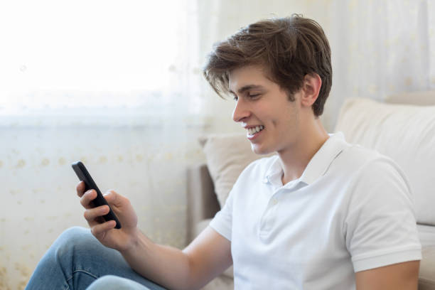 istock Happy man on the phone at home 1195456889