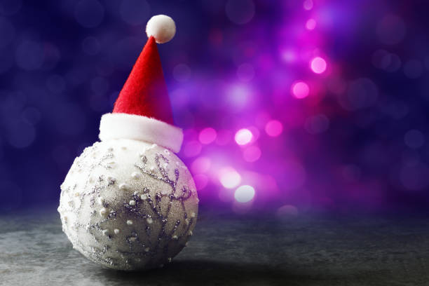 istock Xmas bauble in red Santa hat over defocused Christmas lights 1195458878